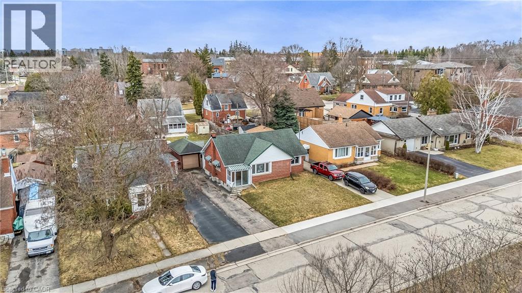 A bird's eye view of a residential neighborhood with houses and parked cars.