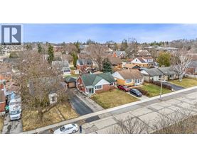 A bird's eye view of a residential neighborhood with houses and parked cars.