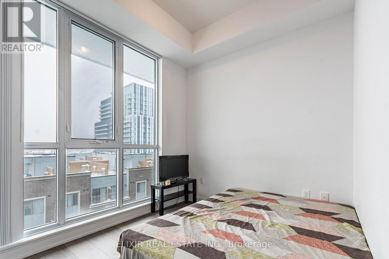 A bedroom with a large bed and a flat screen TV.