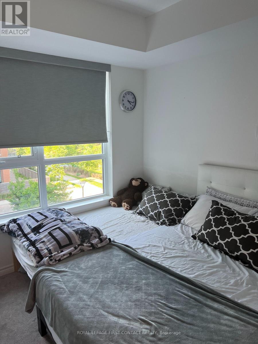 A bedroom with a bed, pillows, and a window with blinds.