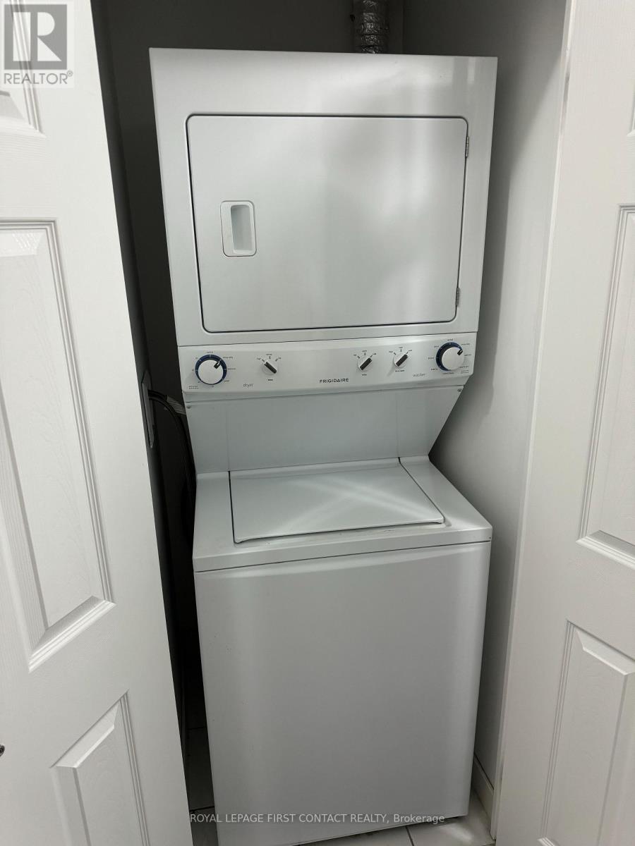 A white dishwasher is in a kitchen with white cabinetry.