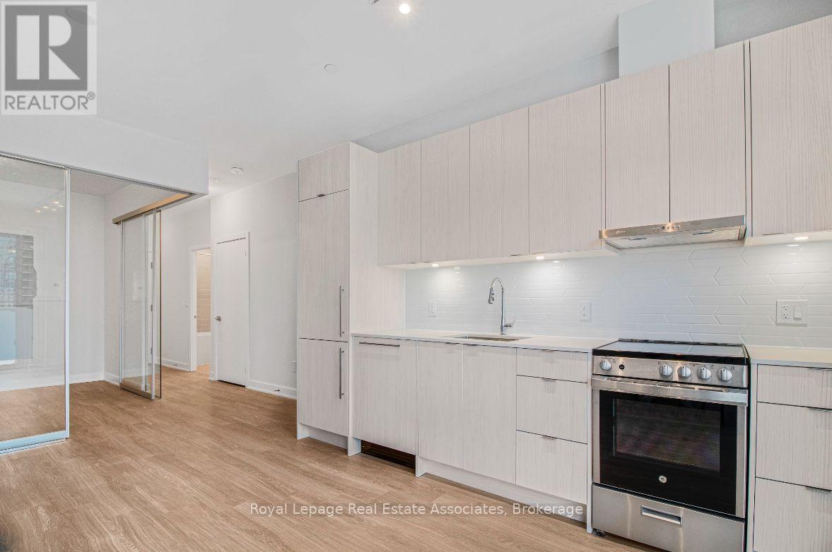A kitchen with white cabinets and a stove top oven.