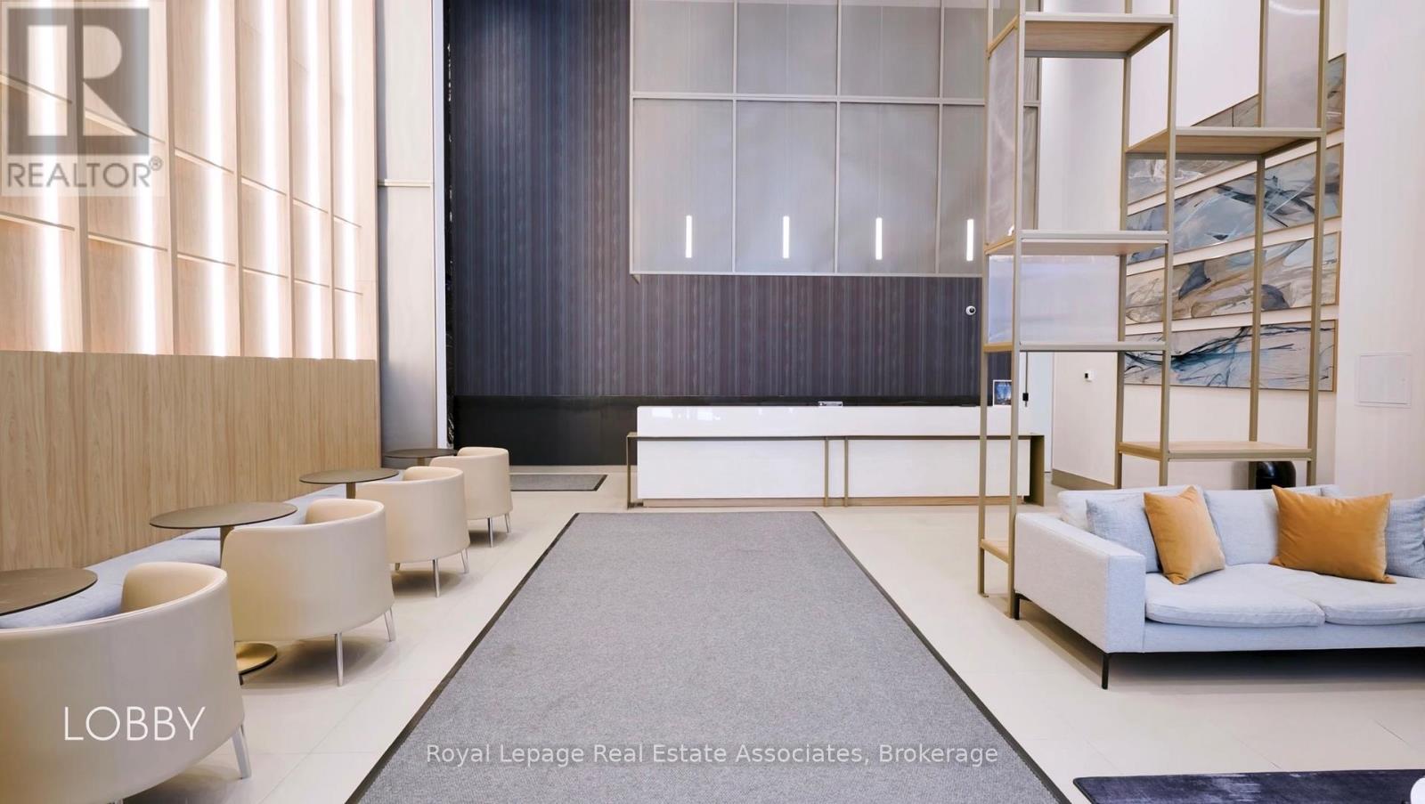 A modern living room with a grey rug and a white sofa.