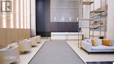 A modern living room with a grey rug and a white sofa.