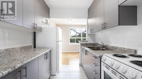A kitchen with granite countertops and white cabinets.