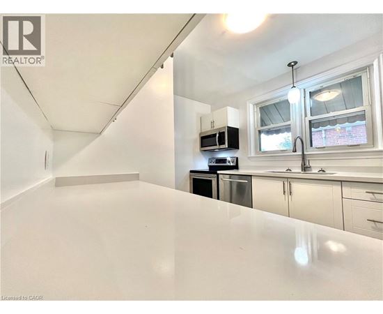 A white kitchen with a microwave and oven built into the cabinetry.
