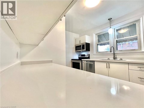 A white kitchen with a microwave and oven built into the cabinetry.
