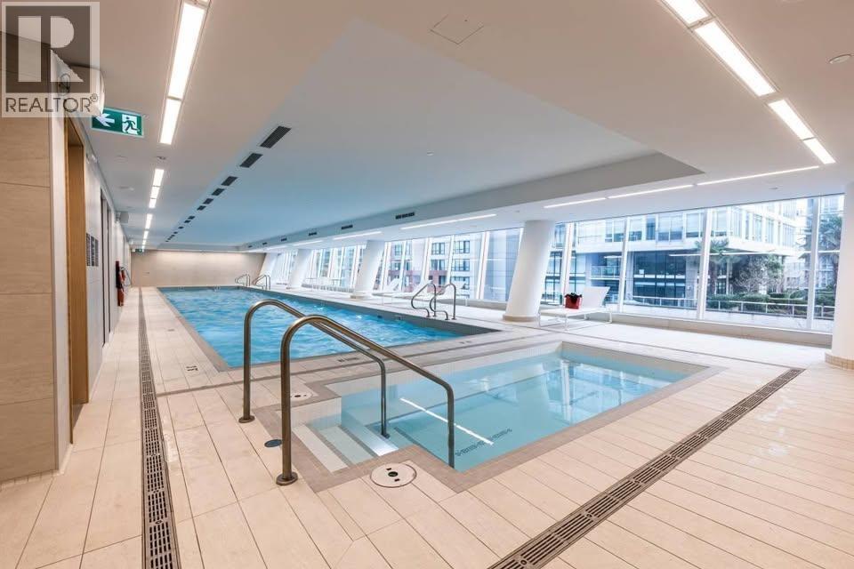 A large indoor swimming pool with a glass divider.