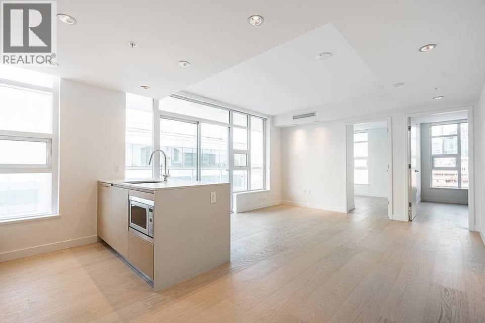 A spacious kitchen with a large island and a window overlooking the city.