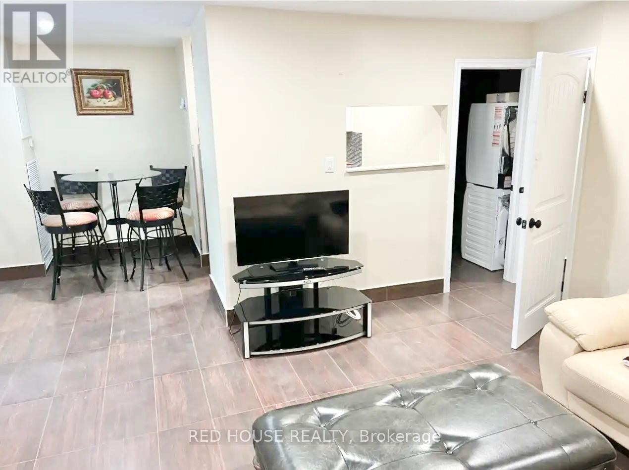 A living room with a television, a sofa, and a table.