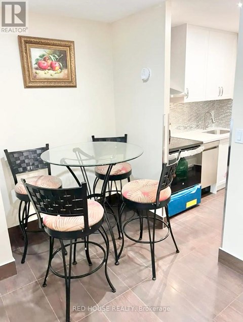 A dining table with four chairs in a kitchen.