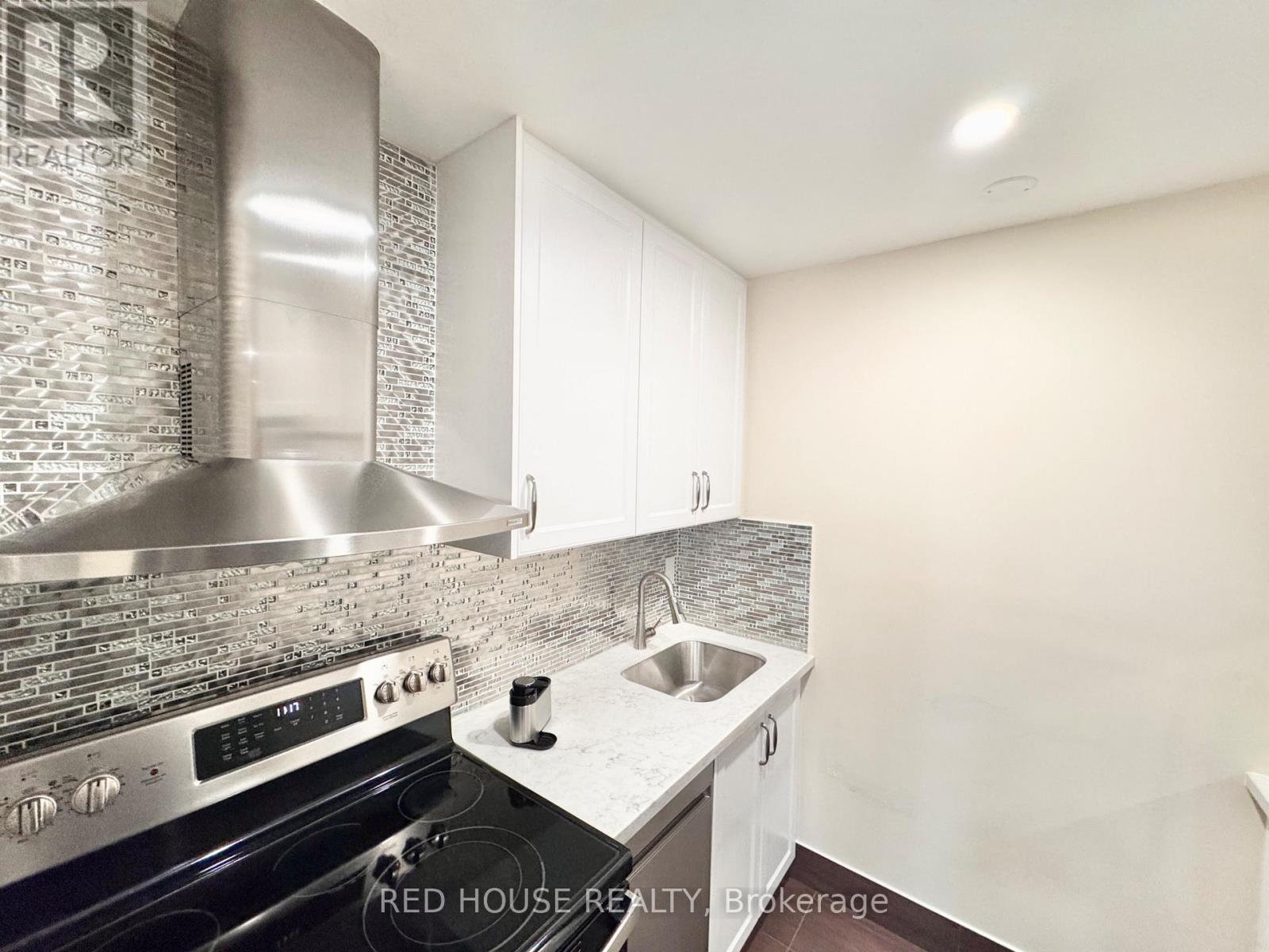 A kitchen with a stove top oven and a refrigerator.