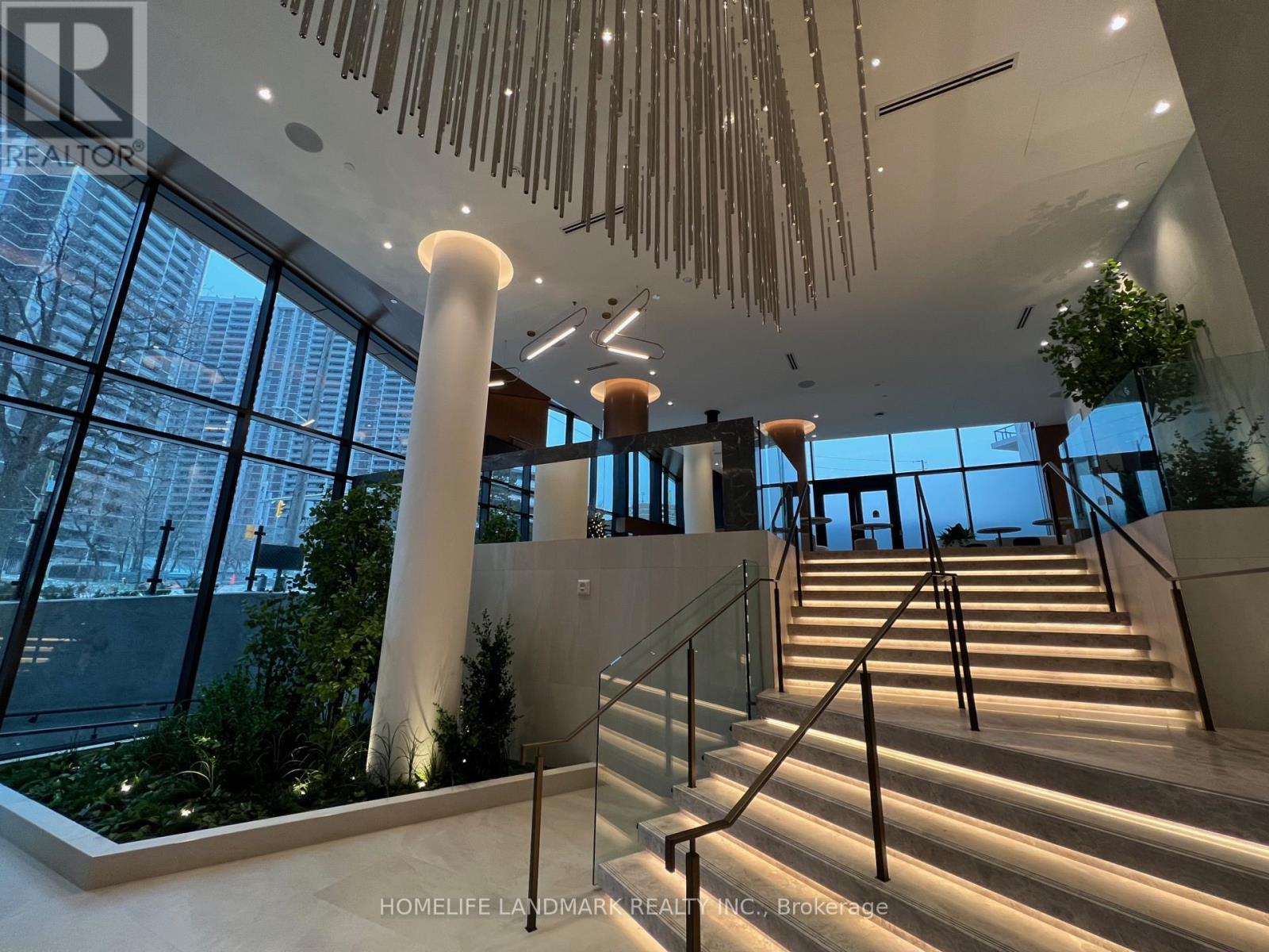 A staircase with a glass railing and a light on the side.