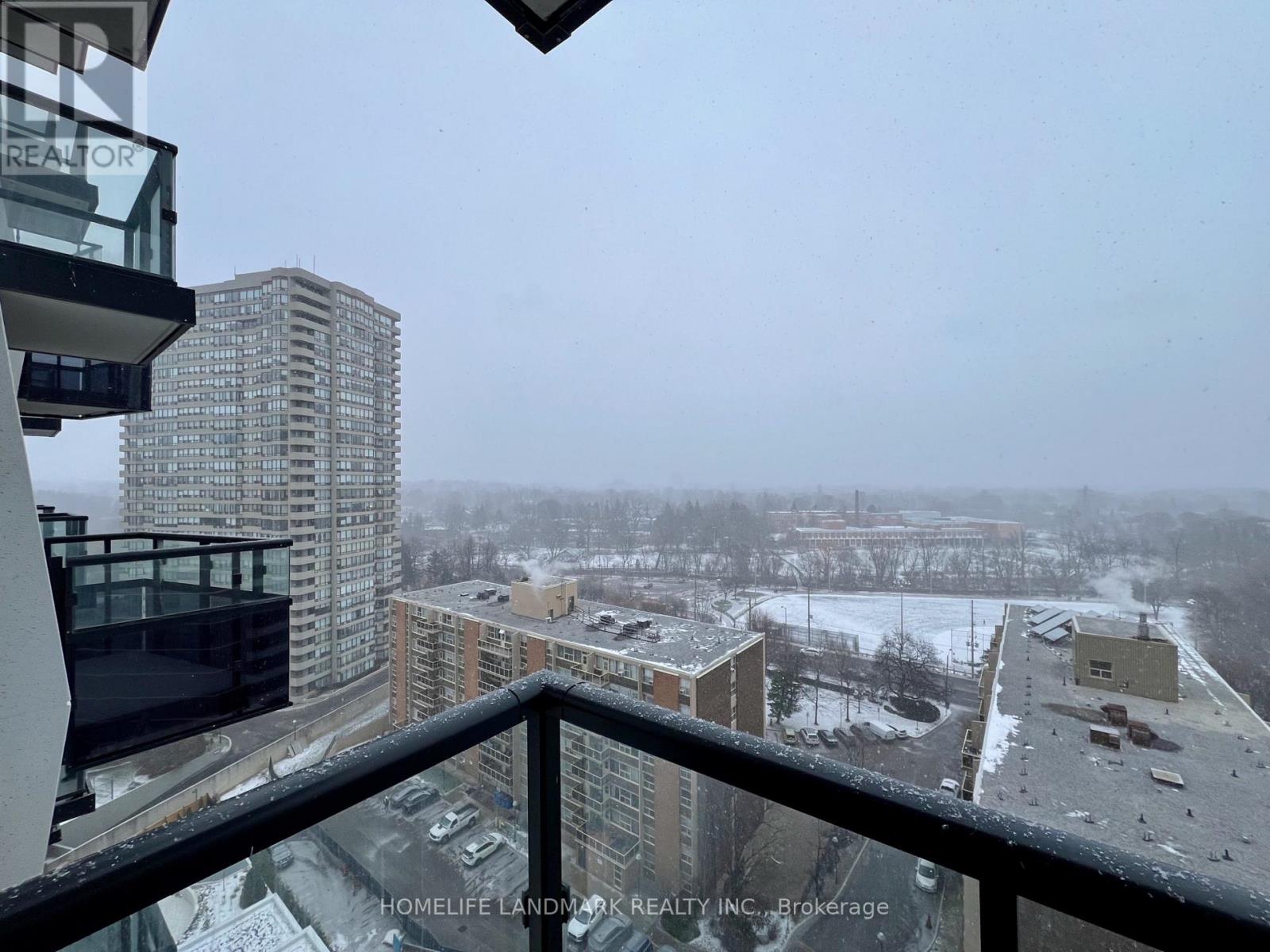 A view from a balcony overlooking a snowy landscape with buildings in the distance.