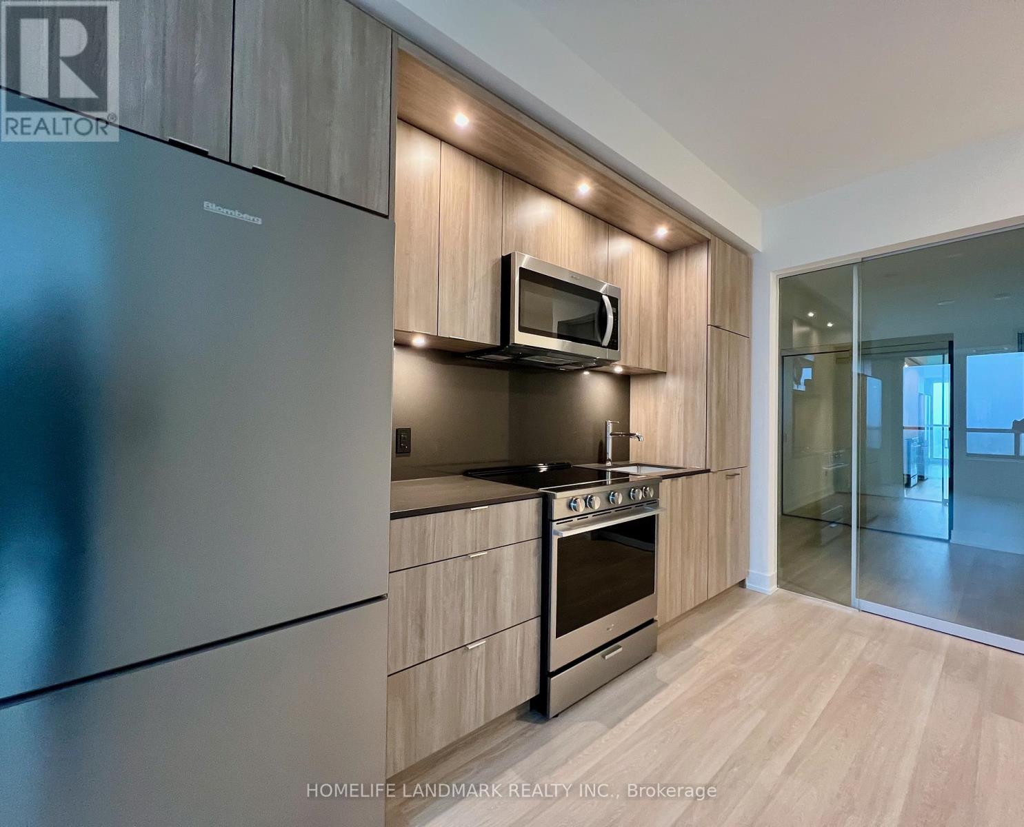 A modern kitchen with wooden cabinets and stainless steel appliances.
