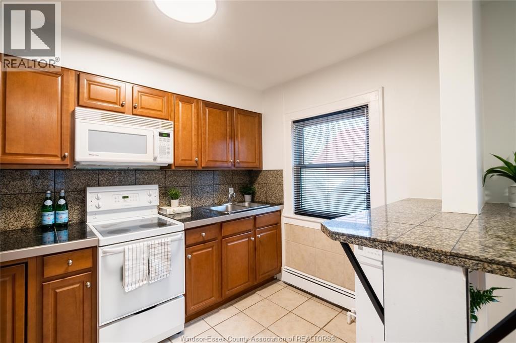 A kitchen with wooden cabinets and a white stove top oven.