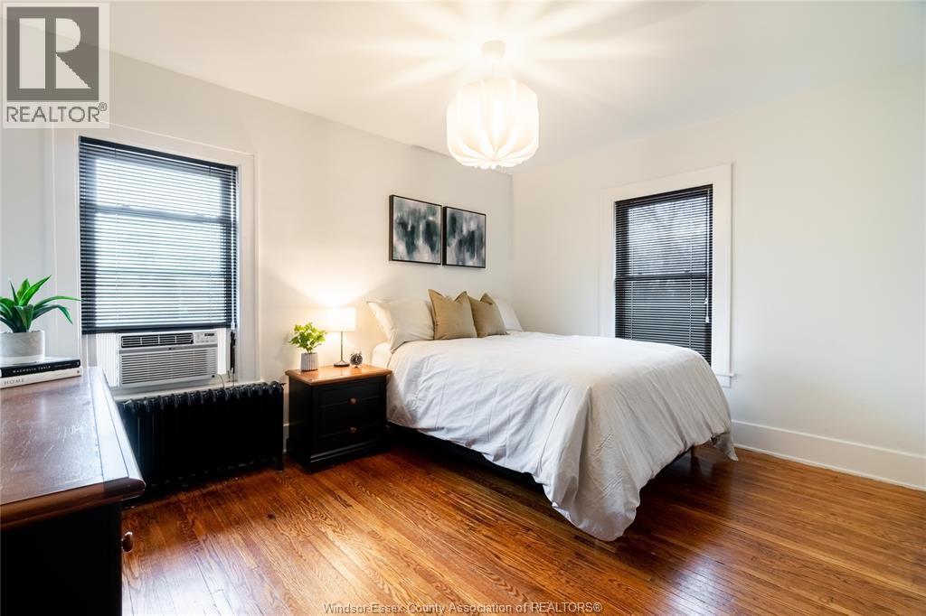 A bedroom with a large bed and a wooden floor.