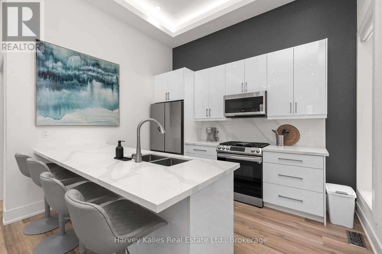 A modern kitchen with a large island and stainless steel appliances.