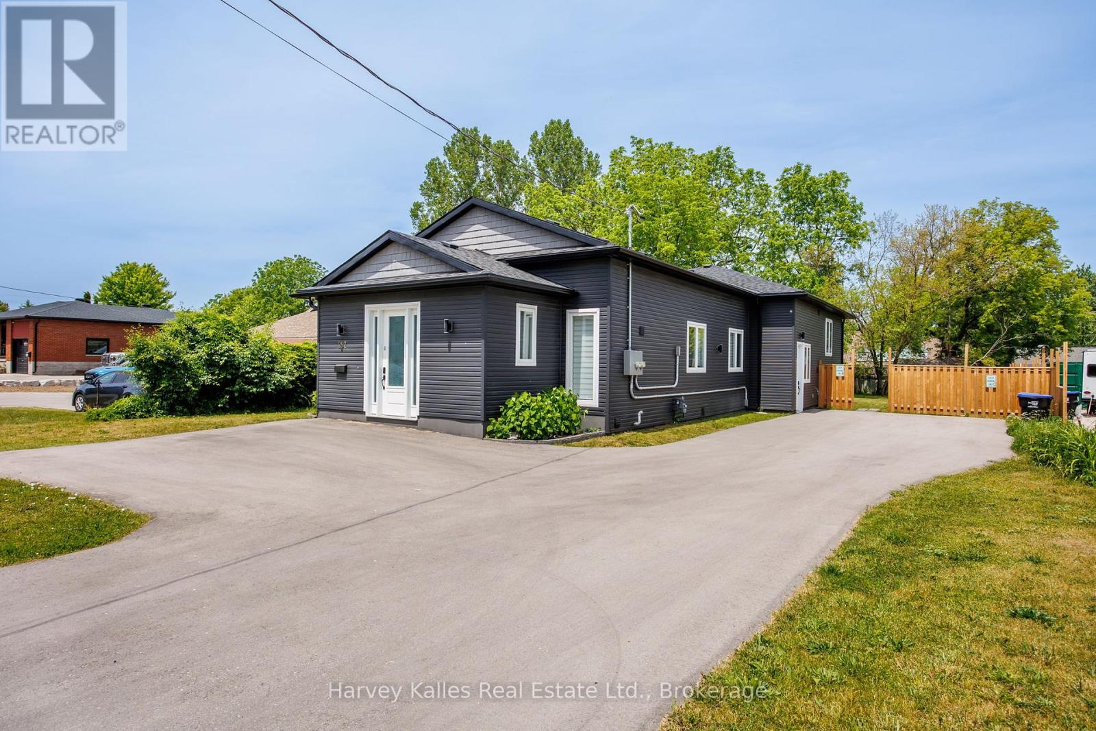 A grey house with a white door and windows is for sale.