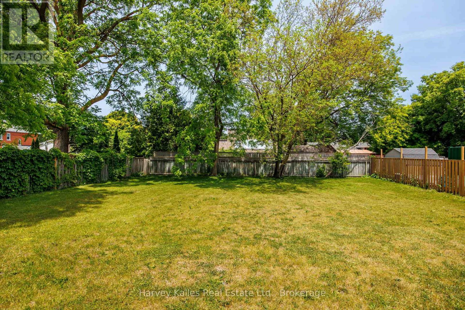 A backyard with a fence and trees.