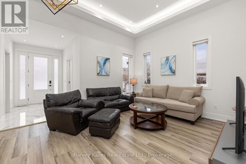 A living room with a black leather sofa set and a wooden coffee table.