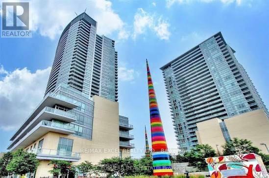 Two tall buildings with a colorful tower in the middle.