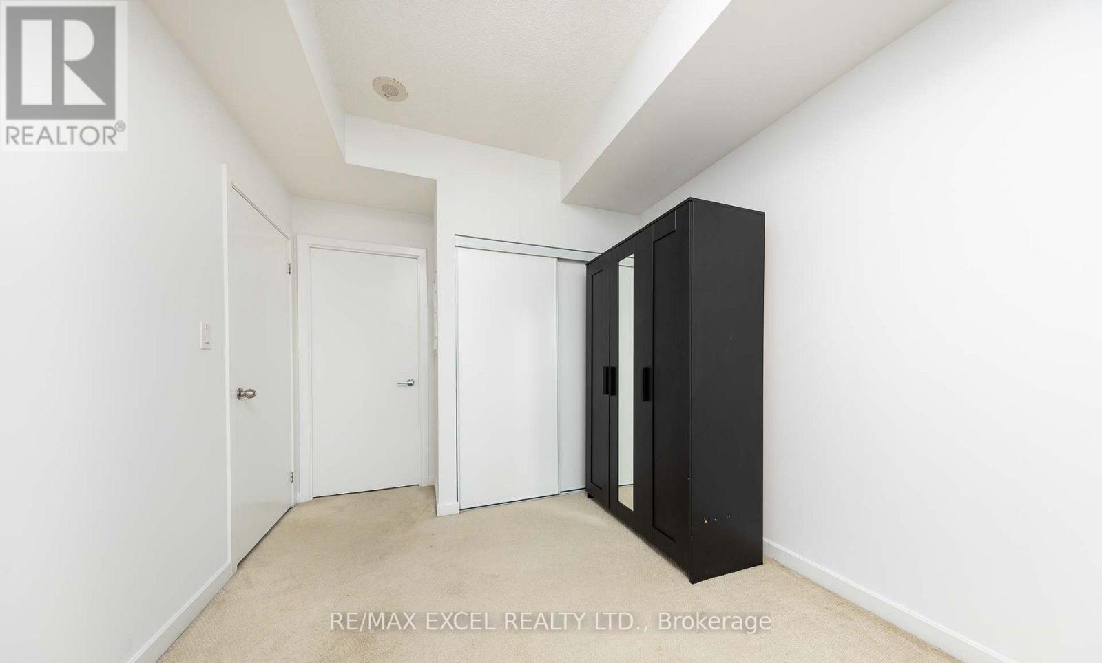 A brokerage sign is on the wall in a white room.