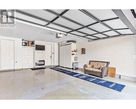 A spacious room with a couch, a television, and a blue rug on the floor.