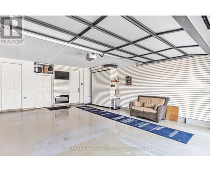 A spacious room with a couch, a television, and a blue rug on the floor.