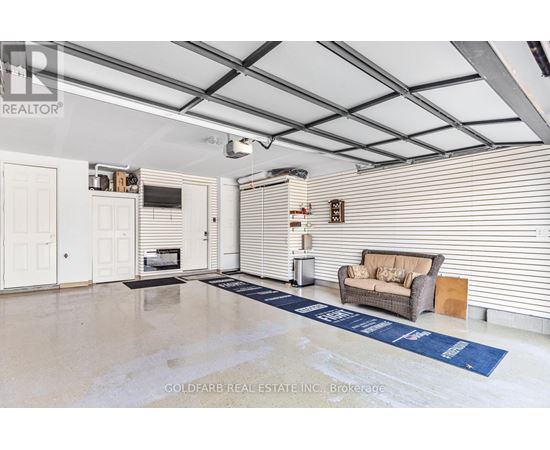 A spacious room with a couch, a television, and a blue rug on the floor.