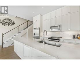 A modern kitchen with white cabinets and a stainless steel sink.