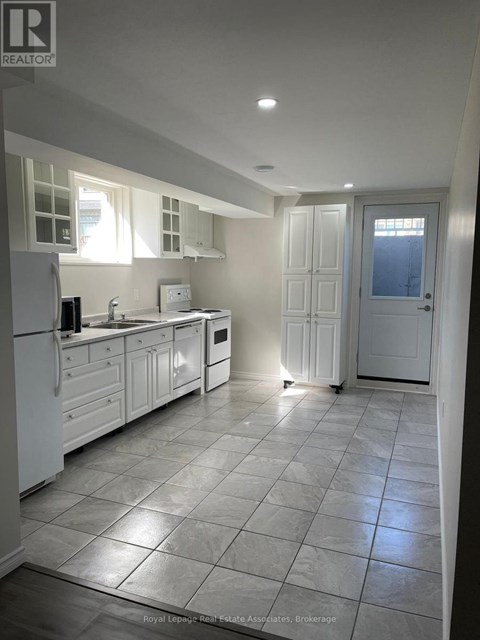 A kitchen with white appliances and cabinets.