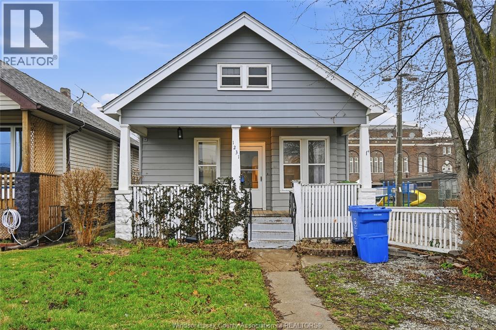 A house with a blue recycling bin on the front porch.
