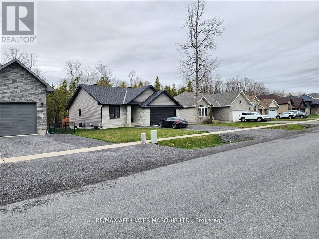 A residential street with houses and cars parked on the side.