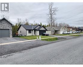 A residential street with houses and cars parked on the side.