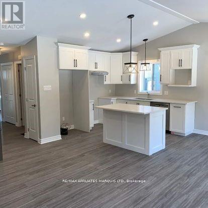 A well-lit kitchen with white cabinets and a central island.
