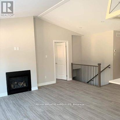 A living room with a fireplace and a staircase.