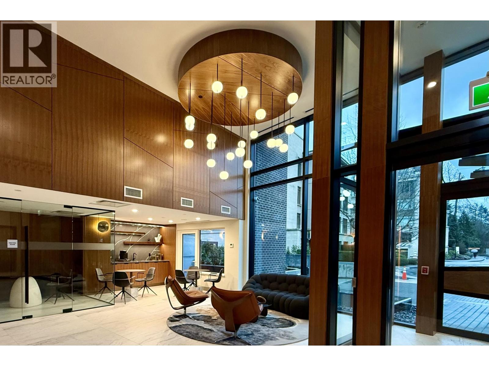 A living room with a couch, chairs, and a rug.
