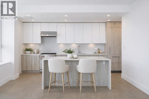 A modern kitchen with white cabinets and a center island.