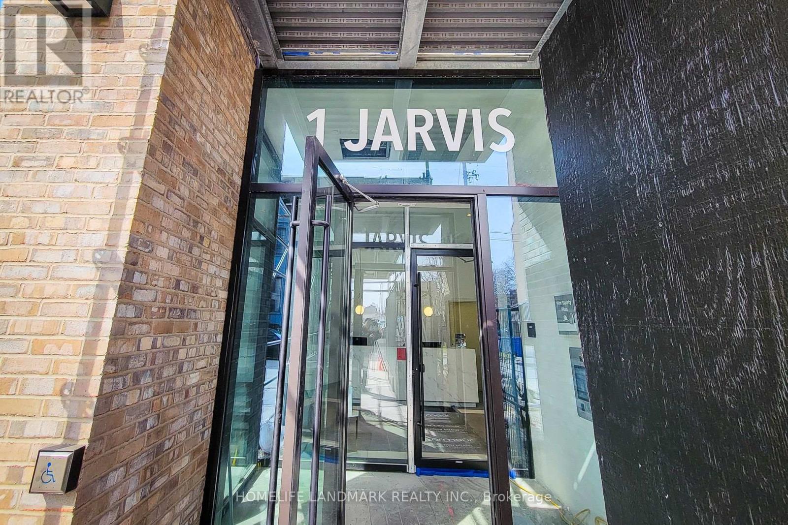The entrance to a building with a glass door and a sign that reads "1 Jarvis.".