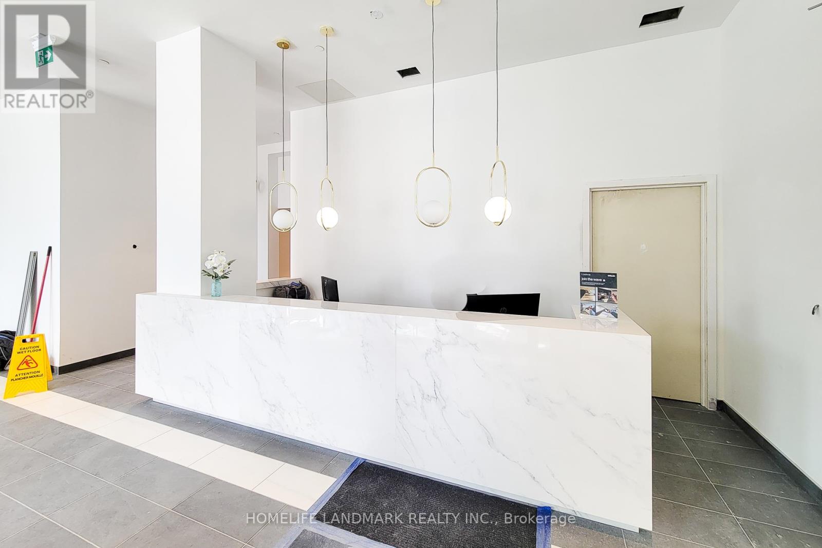 A white reception desk with a sign that says "REALTOR" and a brochure on the desk.