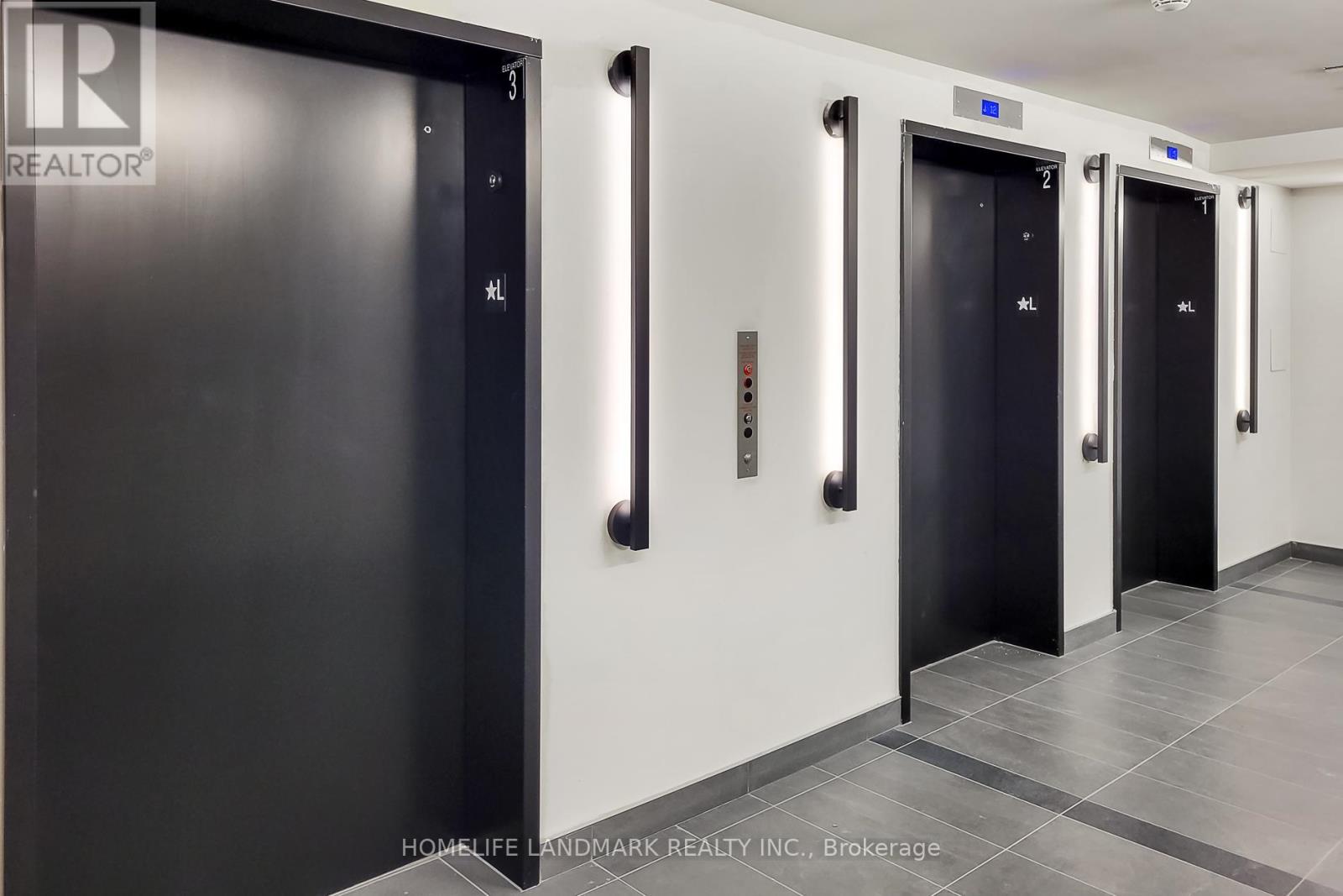 A hallway with three black doors and a white wall.