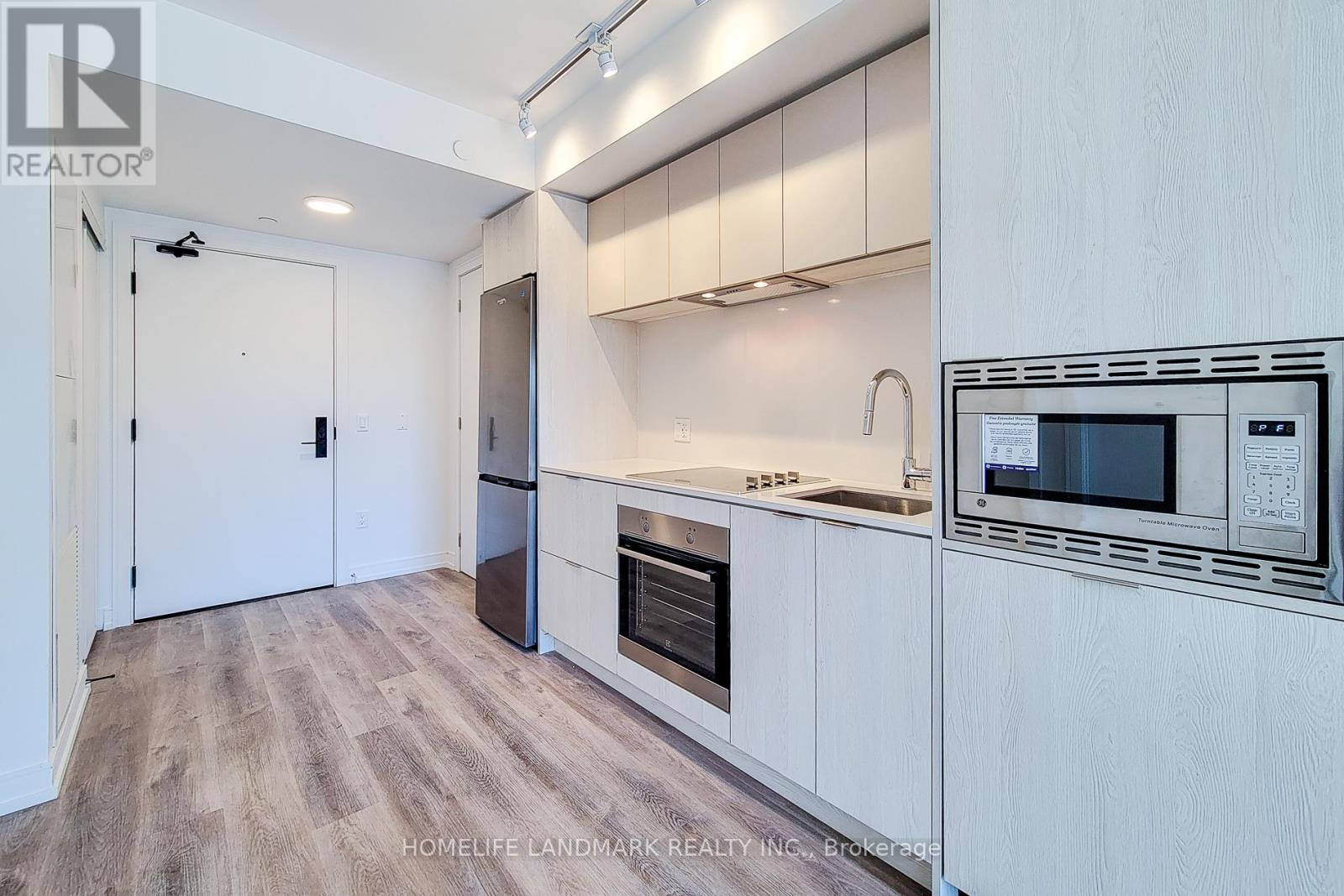 A kitchen with white cabinets and a wooden floor.