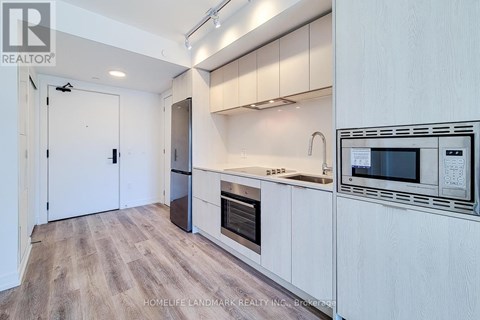 A kitchen with white cabinets and a wooden floor.