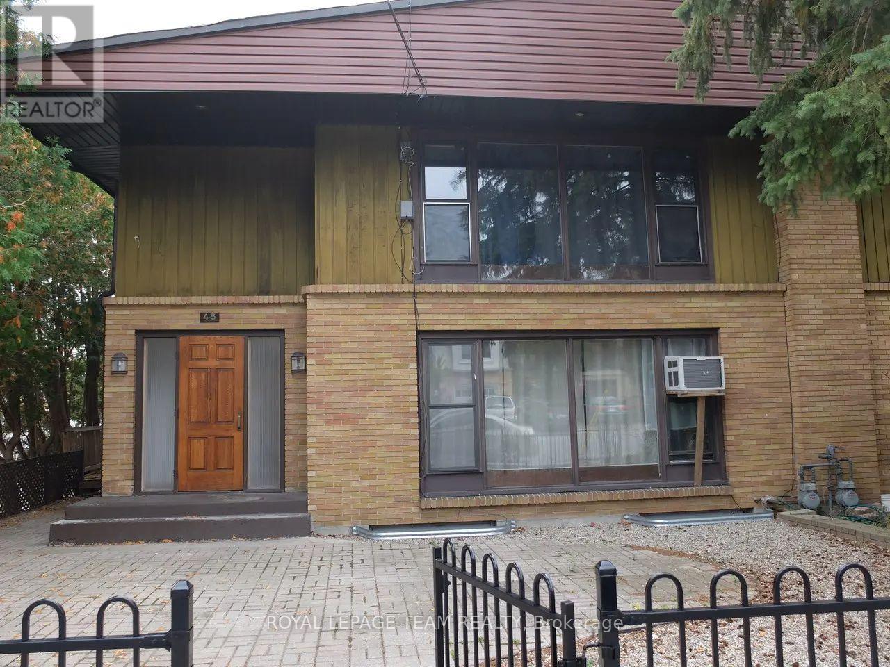 A house with a brown door and a brick wall.
