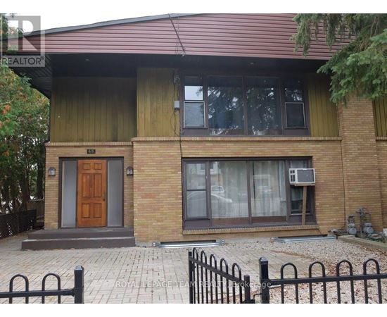 A house with a brown door and a brick wall.