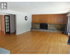 A living room with a fireplace and wooden floors.