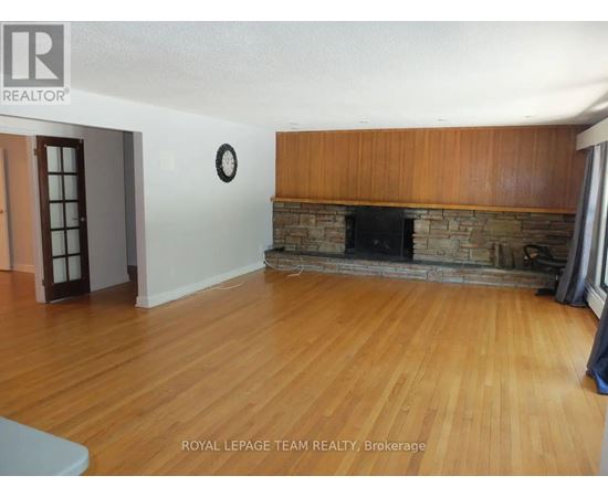 A living room with a fireplace and wooden floors.