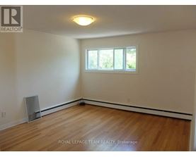 A room with wooden flooring and a window.