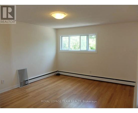 A room with wooden flooring and a window.